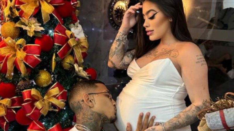 Dynho beirando barriga de Mirela ao lado de árvore de Natal 