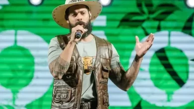 João Carreiro de chapéu e jaleco segurando microfone